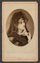 [Woman holding mask]