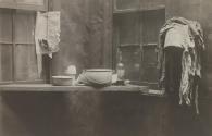 [Dishware and a bottle of liquor near tenement window]
