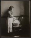 [Girl washing dishes in basin]