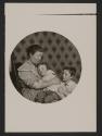 [Mother and two children in tenement]