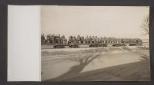 [Soldiers riding in open rail cars]