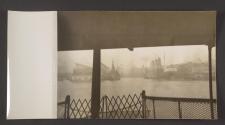 [Warship and transport ship alongside jetties in a harbor.]
