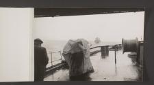 [Looking past a covered gun, over the stern at another transport ship in the convoy]