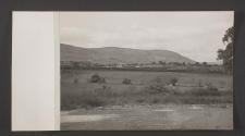 [View of Belfast from an unpaved road next to a field]