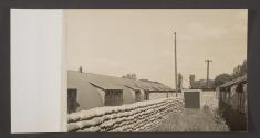 [Quonset huts and sandbag walls]