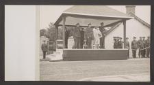 [King George VI, Queen Elizabeth and assorted British Army generals standing on a reviewing platform.]