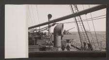 [View of forward gun position, and New York class battleship in the distance]