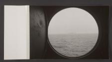 [Transport ship and airship seen through port hole]