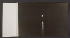 [Light from another ship reflected off the water at night]