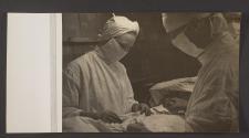 [Doctor and nurse operating on a patient]