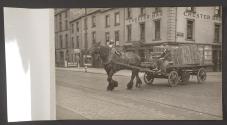 [Horse drawn wagon loaded with baskets exiting Upper Arthur Street, Belfast]