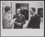 [Yousuf Karsh speaking to two men in front of his work, George Eastman House]