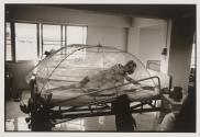 An HIV+ patient at Wat Prabat Nampu reaches for water from underneath his fly net