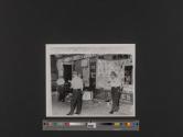Police guard a looted store following violent racial rioting which raged through the night