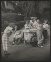 [Teen girl photographs her friends at an ice cream cart]