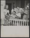 [A group of teens looking at snapshots made by their friend with a camera]