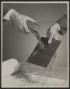 [High speed flash photograph of water being poured across a sheet of cardboard]