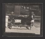 [Woman in a chair behind an old couch on the sidewalk, Philadelphia]
