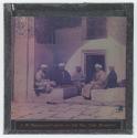 [Five men sitting near doorway]