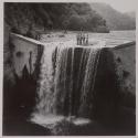 [Land surveyors standing atop a waterfall]