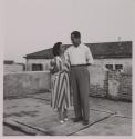 [Woman and man posed on rooftop]