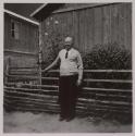 [Man posed near fence]