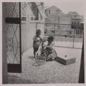 [Giuseppe and Rosa Maria Toscano, children of the photographer, playing with a bicycle]