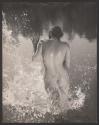 [Nude woman splashing in water]