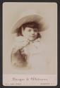 [Young girl with a hat tied on under her chin with a large bow]