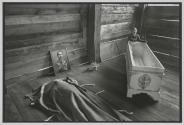 Too young to know what is happening, a boy plays with his mother's coffin