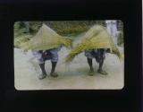 [Man wearing rain gear made of straw]