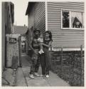 [Family of three on sidewalk, Buffalo, New York]