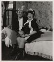 [Man and woman on bed with party hats, Buffalo, New York]