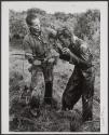 Vietnam 1964- A South Vietnamese Ranger uses a dagger to punish a farmer who allegedly supplied wrong information about Vietcong activities in the area.
