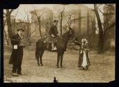 [Elisabeth Freeman dressed as a gypsy, standing next to policeman on horse and man with a camera]