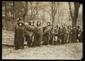 [Group of ten women with cloaks and walking sticks, holding a banner for the "Votes for Women Pilgrimage from New York City to Washington DC"]