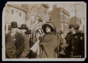 [Rosalie Gardner Jones (the "General") carrying an American flag, leading the Suffrage Hike down a city street]
