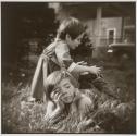 [Two children playing on a residential lawn]