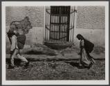 [Man and woman walking up cobblestone road]