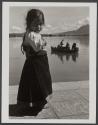 [Portrait of a young girl with river and boat in background]