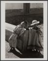 [Two young boys, one wearing a straw hat and poncho]
