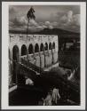 [Fortress with mountains and clouds in background]