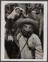 [Parade with masked figures and donkey, Mexico]