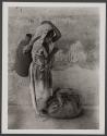 [Girl carrying jug with cloth bundle at feet, Mexico]