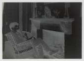 [John Spargo seated by fireplace]