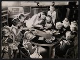 [Teacher attending to small children]