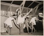 [Women in sailor dresses dancing on stage]
