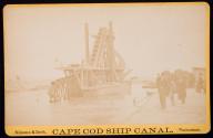 [Bucket dredge in canal with group on shore]