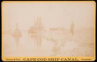 [Man on shore and bucket dredge and tugboat in Cape Cod Canal]