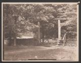 [Wooden gate and stone fence in forest]